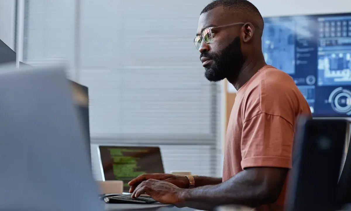 Un homme concentré sur son clavier, une réussite de reconversion data engineer.