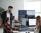Un lead developer discute du code avec un collègue, peut-être pour négocier son salaire.