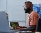 Un homme concentré sur son clavier, une réussite de reconversion data engineer.