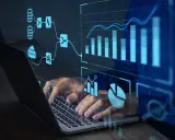 Un homme tape sur un ordinateur portable, avec des graphiques et des flux de données bleus superposés. Idéal pour une formation data scientist à distance.