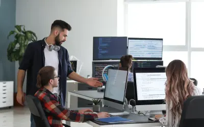 Un lead developer discute du code avec un collègue, peut-être pour négocier son salaire.