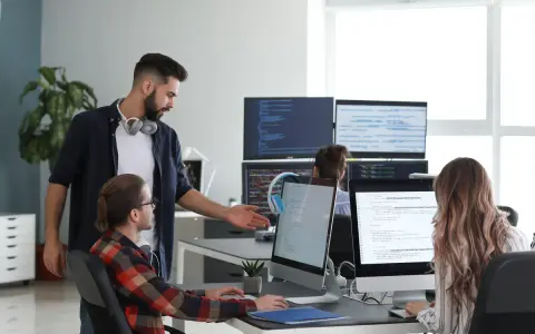 Un lead developer discute du code avec un collègue, peut-être pour négocier son salaire.