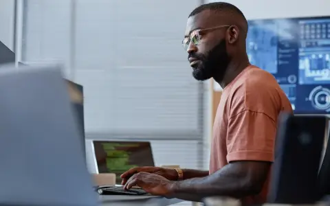 Un homme concentré sur son clavier, une réussite de reconversion data engineer.