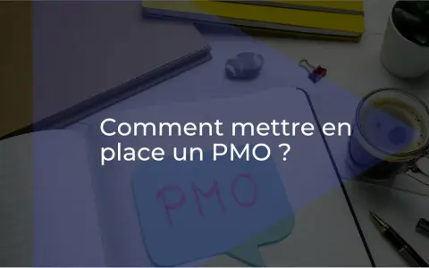 Bureau d'un project management officer : un cahier ouvert avec "Comment mettre en place un PMO ?" écrit dessus, une tasse de café, des stylos et des plantes.