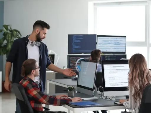 Un lead developer discute du code avec un collègue, peut-être pour négocier son salaire.