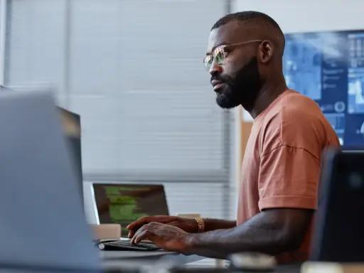 Un homme concentré sur son clavier, une réussite de reconversion data engineer.