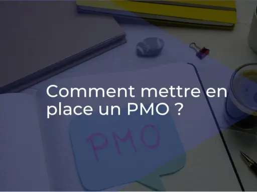 Bureau d'un project management officer : un cahier ouvert avec "Comment mettre en place un PMO ?" écrit dessus, une tasse de café, des stylos et des plantes.